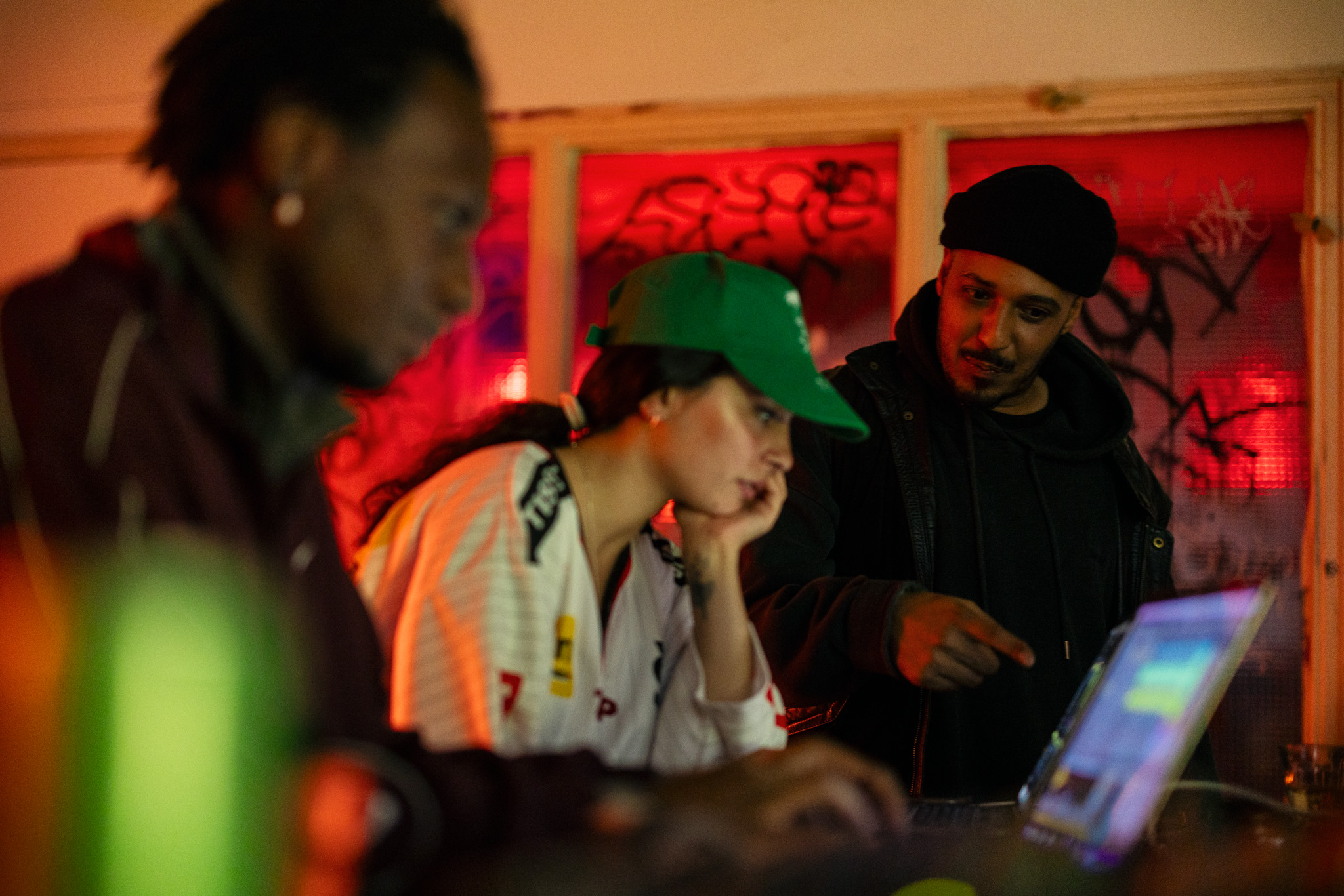 Bamao Yend&eacute;, Noise Diva, and Kelman Duran are looking at the laptop Noise Diva is working on.